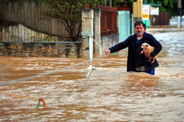 Muškarac se sa psom u rukama probija kroz poplave u Brazilu