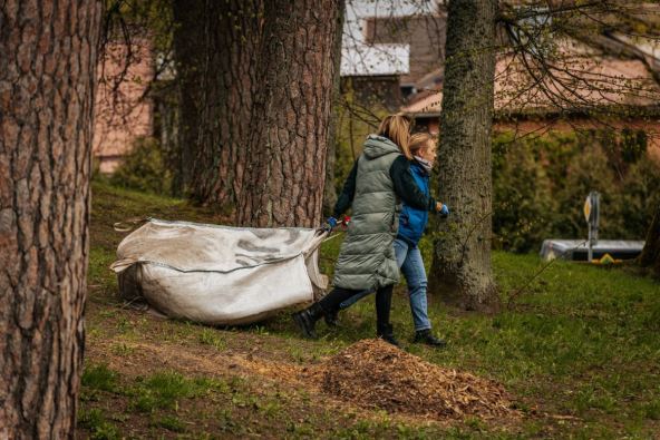 Dve žene nose vreću sa pokupljenim otpadom tokom velikog čišćenja prirode