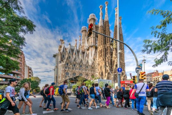 Turisti prelaze pešački prelaz ispred katedrale Sagrada familija